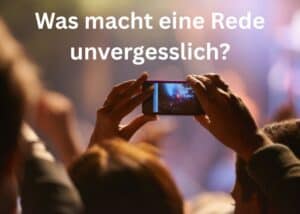 Eine Person h&auml;lt ein Smartphone hoch, um ein Ereignis aufzunehmen; im Hintergrund sind verschwommene Gestalten zu sehen. Der Text auf Deutsch lautet: &bdquo;Was macht eine Rede unvergesslich?&ldquo;.