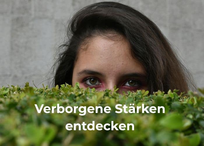 Frau blickt hinter grünen Pflanzen hervor. Text: Verborgene Stärken entdecken.