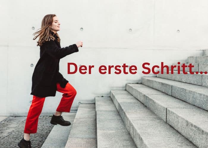 Eine Frau in roten Hosen und einem schwarzen Mantel steigt lächelnd eine Betontreppe hinauf. Über das Bild läuft der deutsche Text „Der erste Schritt...“.